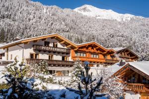 a hotel in the mountains with snow on the ground at Hotel zur Pfeffermühle in Sankt Anton am Arlberg