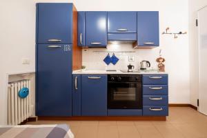 a kitchen with blue cabinets and a stove at GetTheKey Monari Studio in Bologna