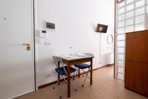 a room with a table and two chairs and a door at GetTheKey Monari Studio in Bologna