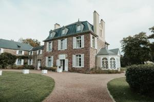 a large brick building with a large window at Domaine des Longrais in Saint-Thurial