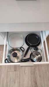 une cuisinière avec des casseroles et des poêles dans un tiroir dans l'établissement Studio calme et discret, à Brest