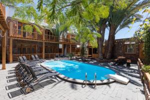 a swimming pool with lounge chairs and a house at The Bridge Dahab in Dahab