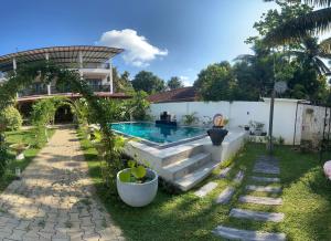 a backyard with a swimming pool and a house at Garden Villa Talalla in Talalla