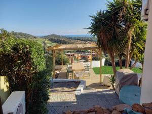 a patio with a pergola and a table and chairs at Casa Buenavista Villasimius in Villasimius