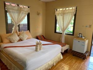 a bedroom with a bed with white sheets and windows at Starlight Haadrin Resort in Haad Rin