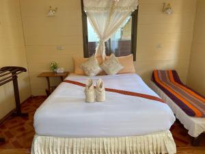 two pairs of shoes sitting on a bed at Starlight Haadrin Resort in Haad Rin