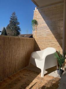 a white chair sitting on a patio next to a fence at The Golden white, Luxury T3 in Annecy