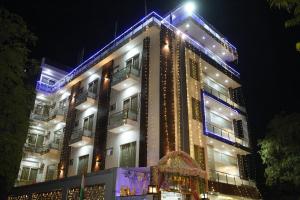 a large building with lights on it at night at Dwelling Residency in Greater Noida