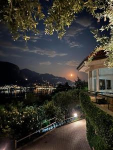 een nachtzicht op een huis met uitzicht op een stad bij Hotel Ristorante Parco Belvedere in Pescate