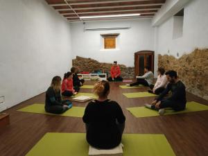 um grupo de pessoas sentadas em uma aula de yoga em Mas Can Puig de Fuirosos em Barcelona