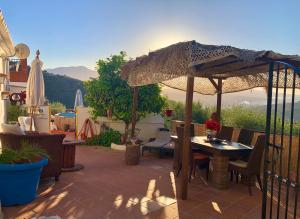 eine Terrasse mit einem Tisch und einem Sonnenschirm in der Unterkunft Casa Ganesha in Comares