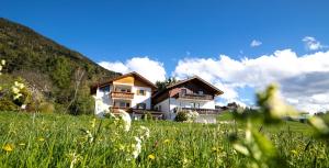 une maison sur une colline dans un champ d'herbe dans l'établissement Residence Alpenrose, à Bressanone