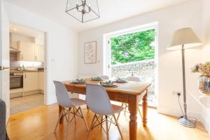 een keuken en eetkamer met een houten tafel en stoelen bij Oxfordshire Living - The Henrietta Cottage - Woodstock in Woodstock