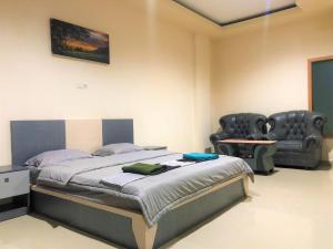 ein Schlafzimmer mit einem Bett, einem Sofa und einem Stuhl in der Unterkunft MS Hotel Pinrang Mitra RedDoorz in Pinrang
