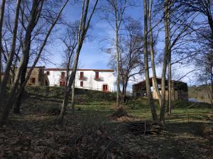 a white house in the middle of trees at Mas Can Puig de Fuirosos in Barcelona