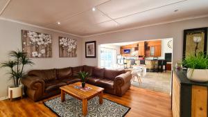 un soggiorno con divano marrone e tavolo di Lido Living a East London