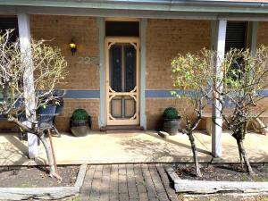 una porta d'ingresso di una casa con due alberi di Cute Cottage On Byng - Walk to Town a Orange