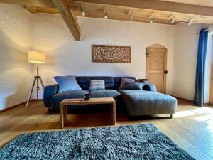 a living room with a blue couch and a table at Chalet Alpenflair in Pfronten