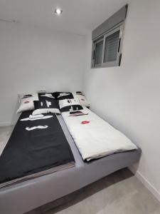 a bed with black and white pillows on it at Mirador 2 in San Jorge