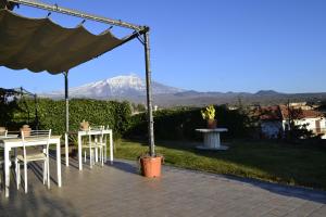a table and chairs with a mountain in the background at Good Morning Etna in Bronte