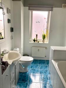 a bathroom with a toilet and a sink and a window at Apartament Deluxe in Jelenia Góra
