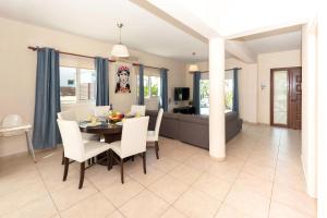 a dining room and living room with a table and chairs at Villa Carolina in Ayia Napa