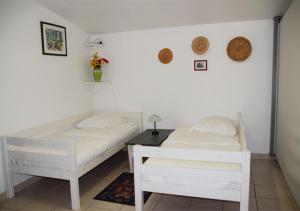 a bedroom with two beds and a table at La Maison Des Invites in Pernes-les-Fontaines
