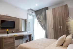 a bedroom with a bed and a desk and a television at Mary Vi Rooms in Peschici