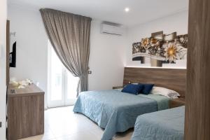 sypialnia z 2 łóżkami i oknem w obiekcie Mary Vi Rooms w mieście Peschici