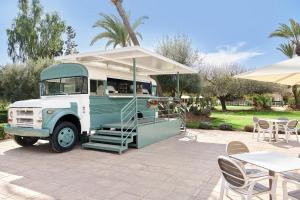 un ancien camion-restaurant vert et blanc avec une tente dans l'établissement Iberostar Club Palmeraie Marrakech All Inclusive, à Marrakech