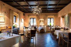 un restaurante con mesas y sillas blancas y una lámpara de araña en Alpenhof en Bayrischzell