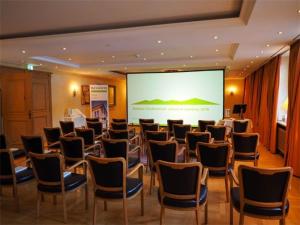 a room with a bunch of chairs and a screen at Alpenhof in Bayrischzell +35 photos