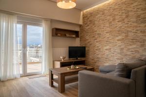 a living room with a tv and a brick wall at Sea View Volos in Volos