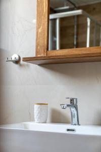 a bathroom sink with a cup on top of it at Sea View Volos in Volos +26 photos