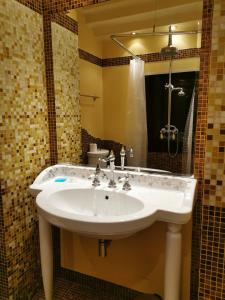 La salle de bains est pourvue d'un lavabo blanc et d'un miroir. dans l'établissement Venice Dose Suite, à Venise