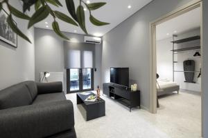 a living room with a couch and a television at Athenian Island Project in Athens