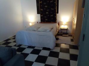 a bedroom with a bed and a checkered floor at Source AUGER in Gruchet-le-Valasse