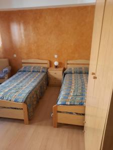 duas camas num pequeno quarto com duas camas sidx sidx em HABITACIONES PENSION EL PARQUE em Sabiñánigo