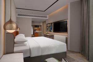 Tempat tidur dalam kamar di Home2 Suites By Hilton Wuhan Hankou Railway Station