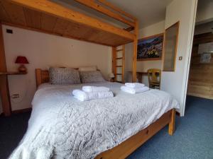 a bedroom with a large bed with towels on it at Hôtel L'Echaillon in Névache