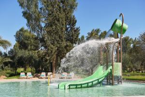 un toboggan dans un parc avec une fontaine dans l'établissement Iberostar Club Palmeraie Marrakech All Inclusive, à Marrakech