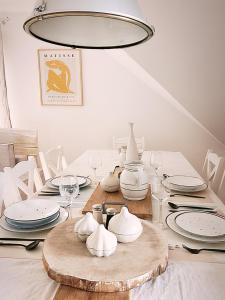 uma sala de jantar com uma mesa com pratos e um lustre em FORMA Apartament Supraśl em Supraśl