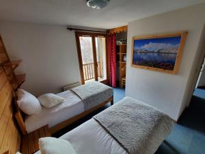 - une chambre avec 2 lits et une fenêtre dans l'établissement Hôtel L'Echaillon, à Névache