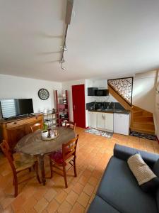 sala de estar con mesa y cocina en Maison de campagne, Gîte rouge en Brigné