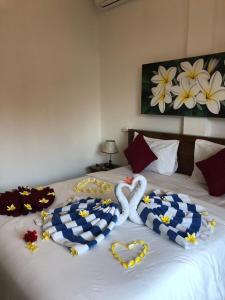 uma cama com dois cisnes feitos de toalhas em Juan Beach Bungalow em Nusa Penida