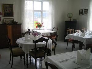 a dining room with white tables and chairs and a window at Skagakaia in Bø i Vesterålen