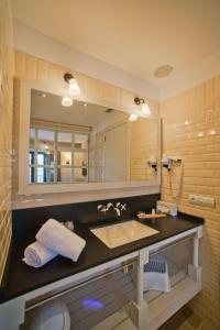 
a bathroom with two sinks and a mirror at Hotel Playa Sol in Cadaqués

