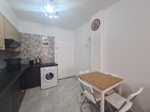 尼科西亞的住宿－Pindarou Apartment，厨房配有桌子和洗衣机。
