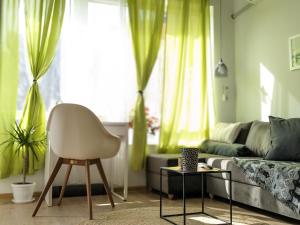 uma sala de estar com uma cadeira e um sofá em Welcome Stara Zagora Apartment 4 Guests Pet Friendly em Stara Zagora