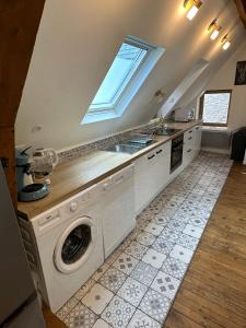 a kitchen with a washing machine and a sink at Superbe appartement mansardé avec mezzanine - proche centre ville, thermes, aquensis in Bagnères-de-Bigorre
